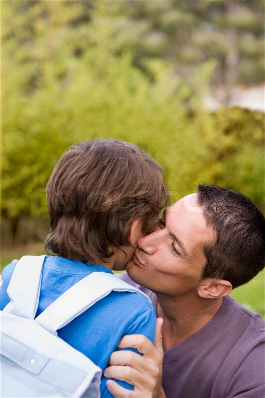 Dad kissing boy going to school, stock photo