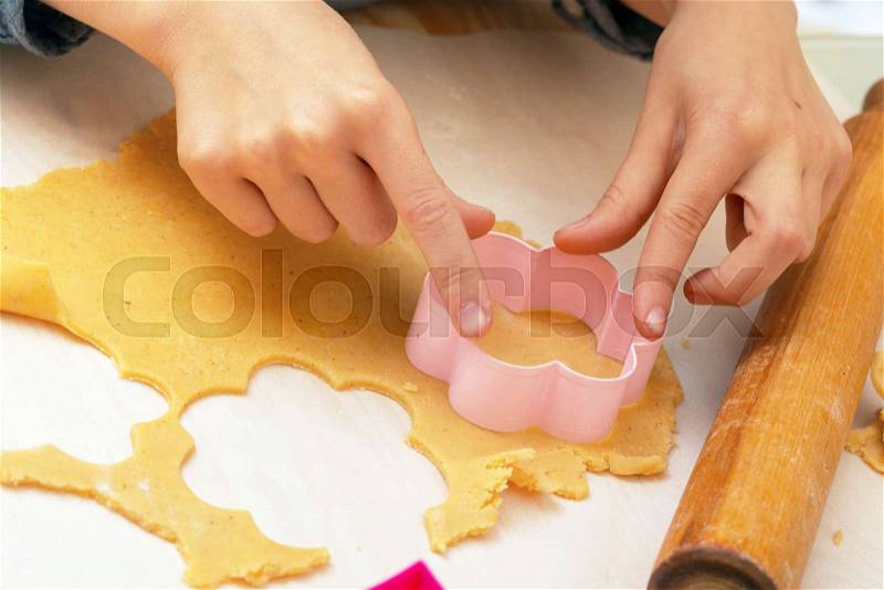 Little girl makes a cookie in the kitchen , stock photo