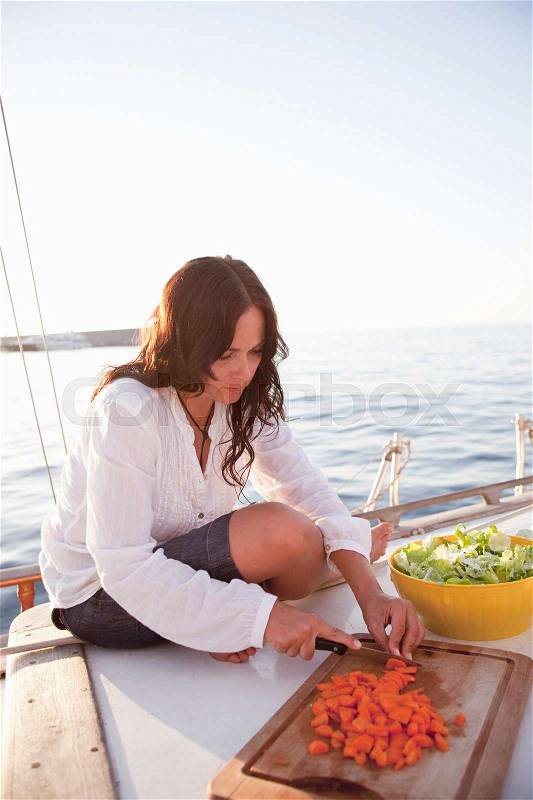 Woman on boat preparing food, stock photo