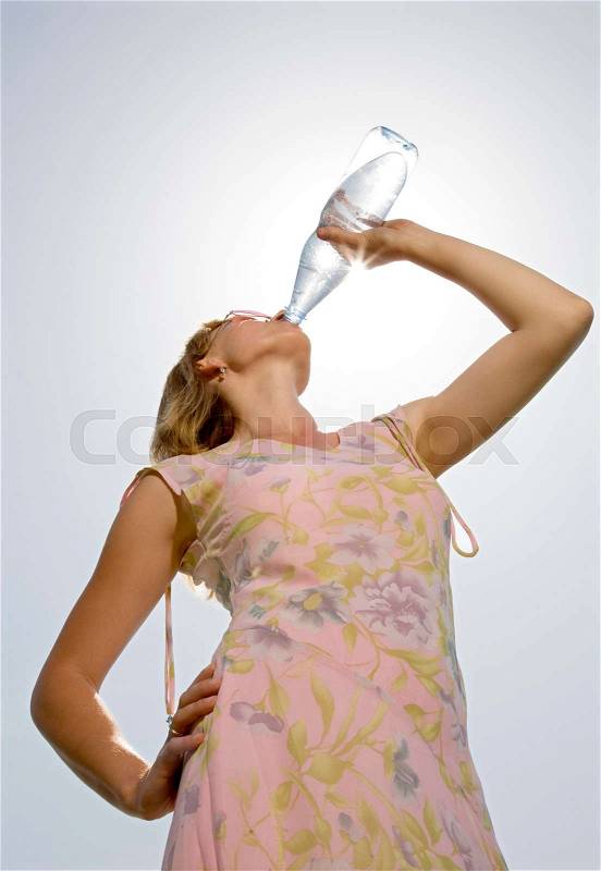 Woman drinking water from bottle, stock photo