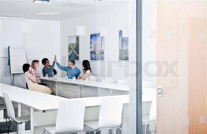 Relaxed work group in meeting room, stock photo