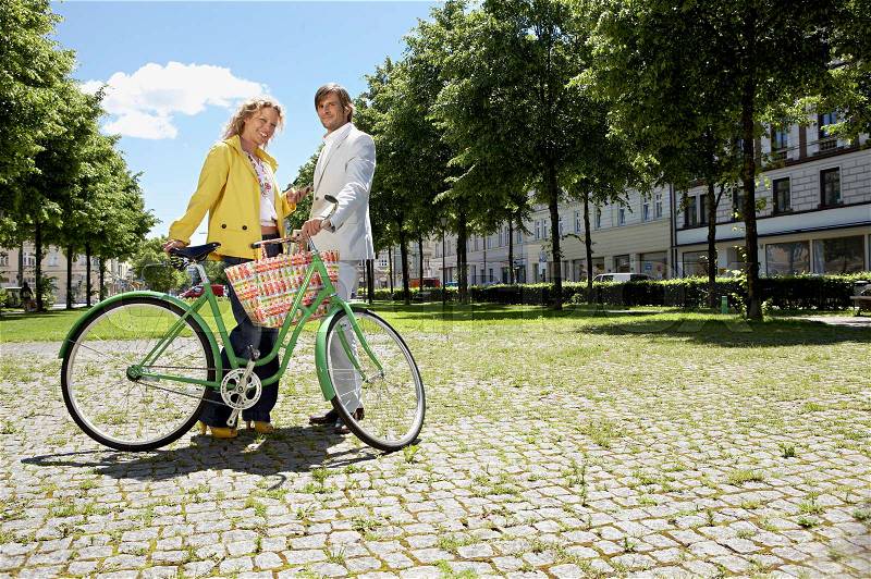 Two people with bicycle in conversation, stock photo