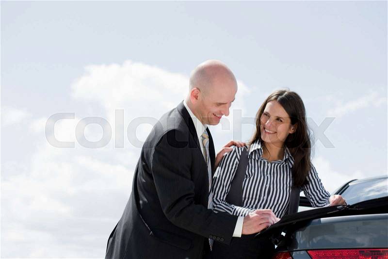 Man signing contract on back of car, stock photo