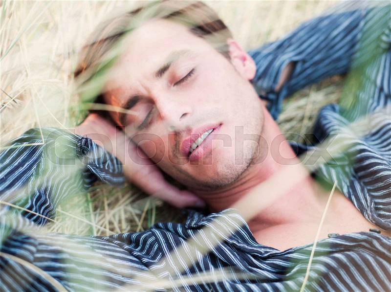Man lying in grass relaxing, stock photo