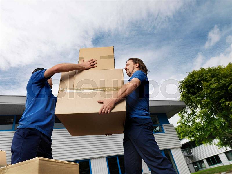 Two men carrying boxes, stock photo
