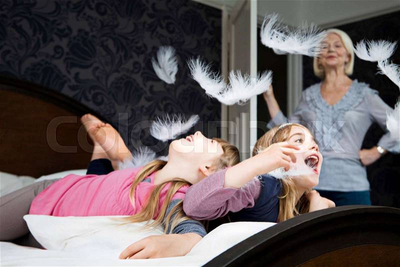 Granny disapproves girls pillow fighting, stock photo