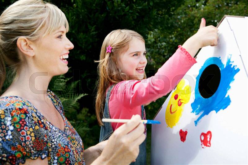 Mother and daughter painting together, stock photo