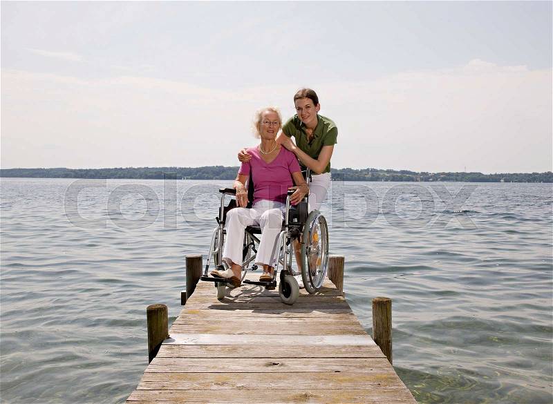 Woman and senior woman in wheelchair, stock photo