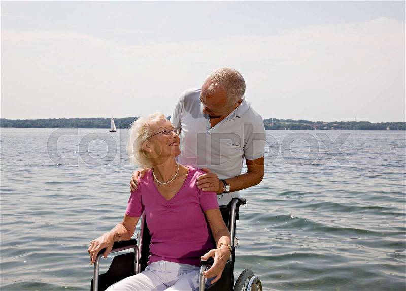 Senior man and woman in wheelchair, stock photo