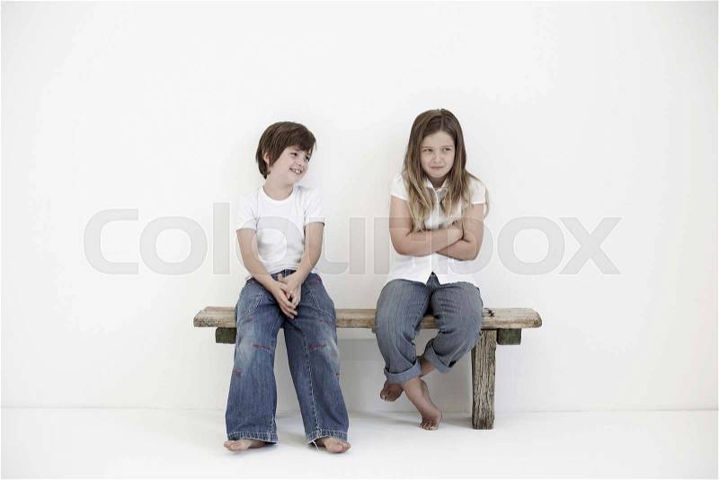 Young boy smiling at shy young girl, stock photo