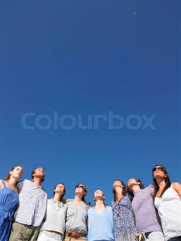 Group of young people looking at sun, stock photo