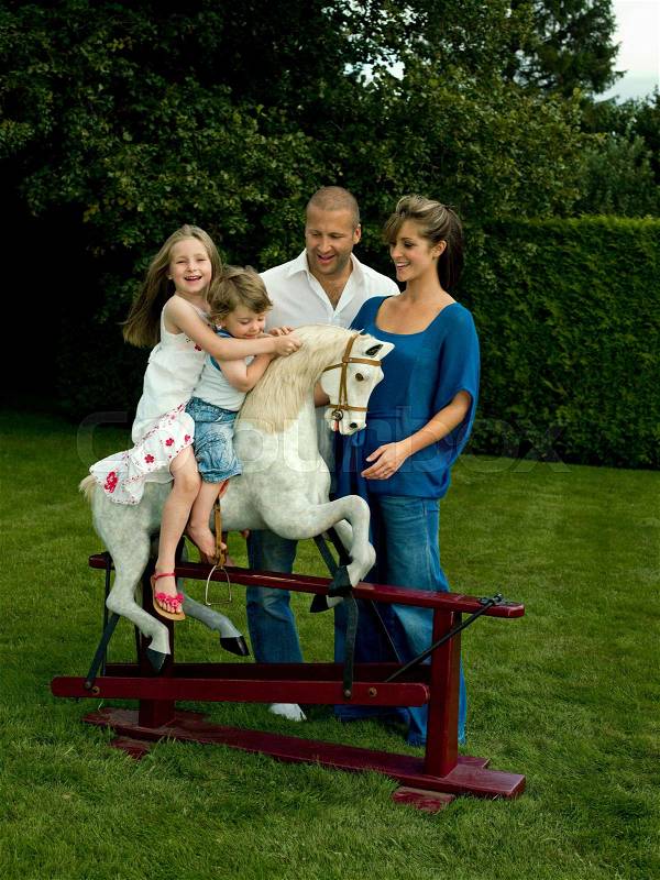 A family playing with a rocking horse, stock photo