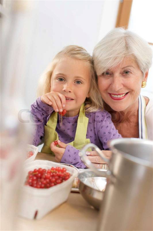 Girl with grandmother cooking jam, stock photo