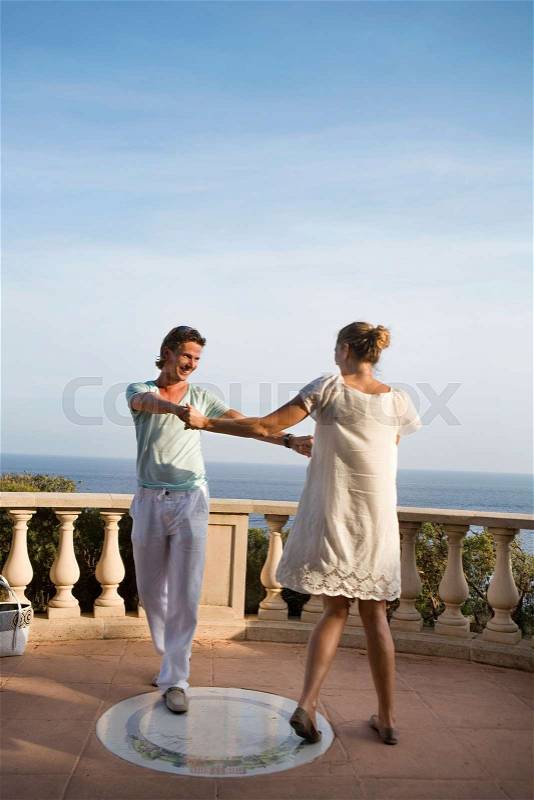 Loving couple dance on balcony, stock photo