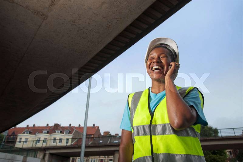Woman construction worker on phone, stock photo