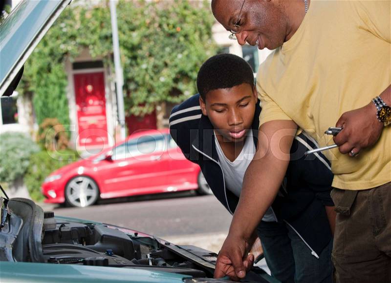 Father & son working on car engine, stock photo