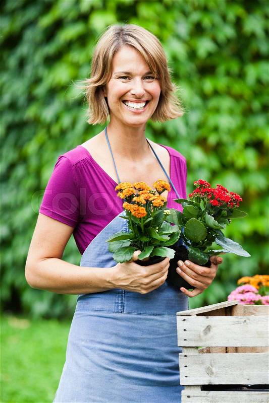Woman holding two sets of flowers, stock photo