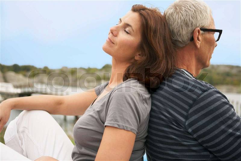 Middle aged couple, back to back, stock photo