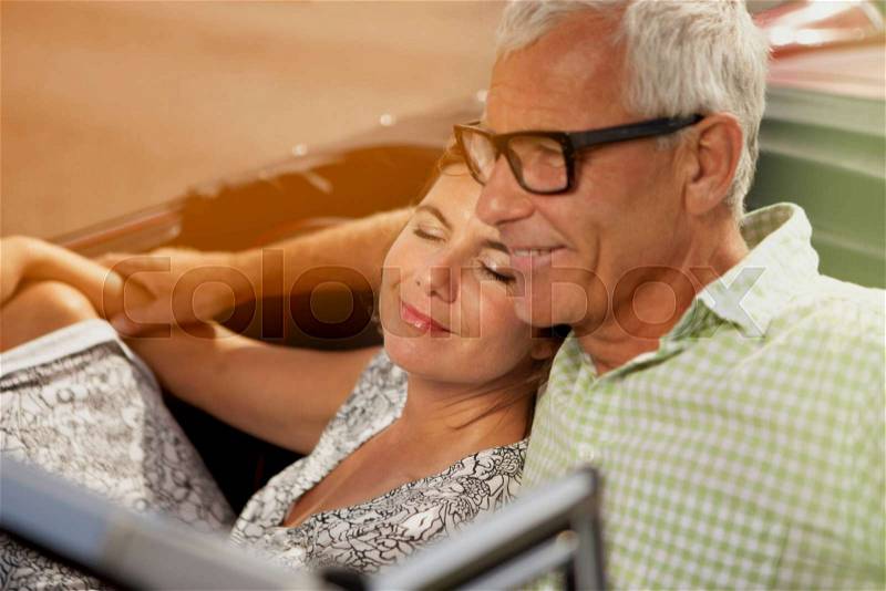 Couple in car, her head on shoulder, stock photo