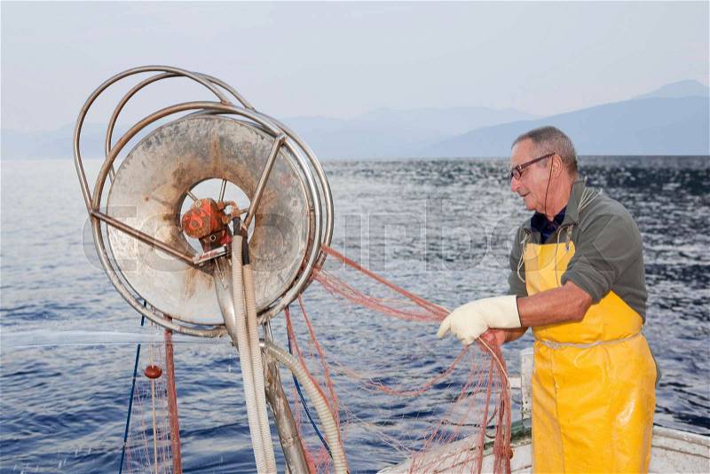 Fisherman on boat, trawling, stock photo