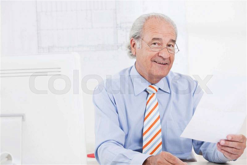 Senior businessman reading a paper, stock photo