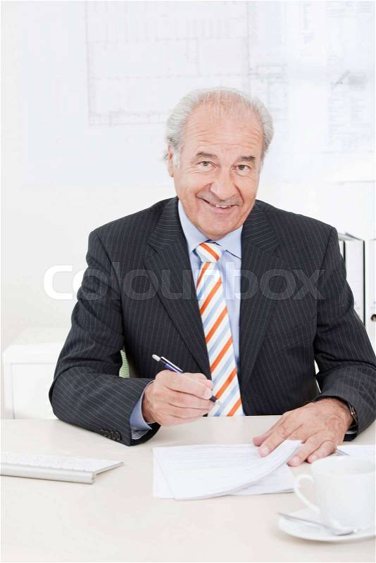 Senior executive signing document, stock photo
