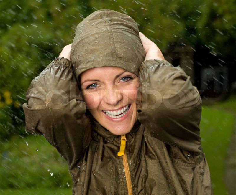 A woman in the rain smiling, stock photo