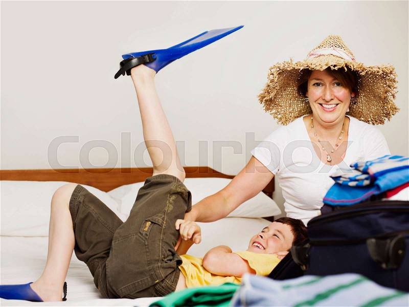 A mother and son packing for holiday, stock photo