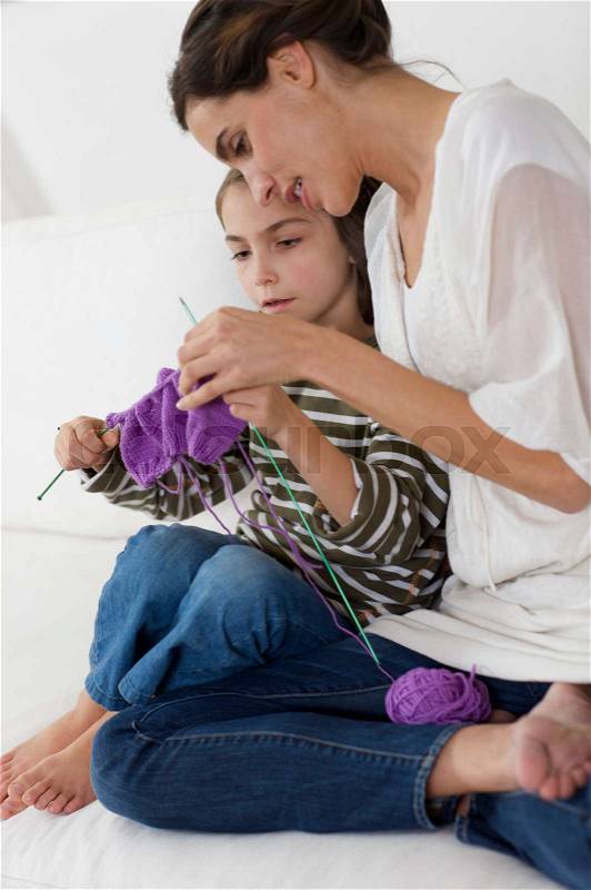 Little girl shown how to knit, stock photo