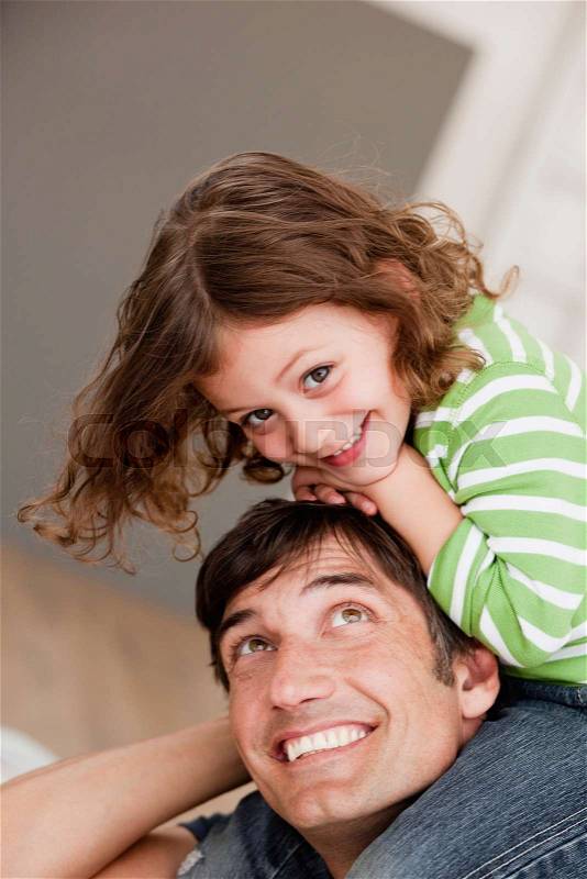 Daughter riding on father's shoulders, stock photo