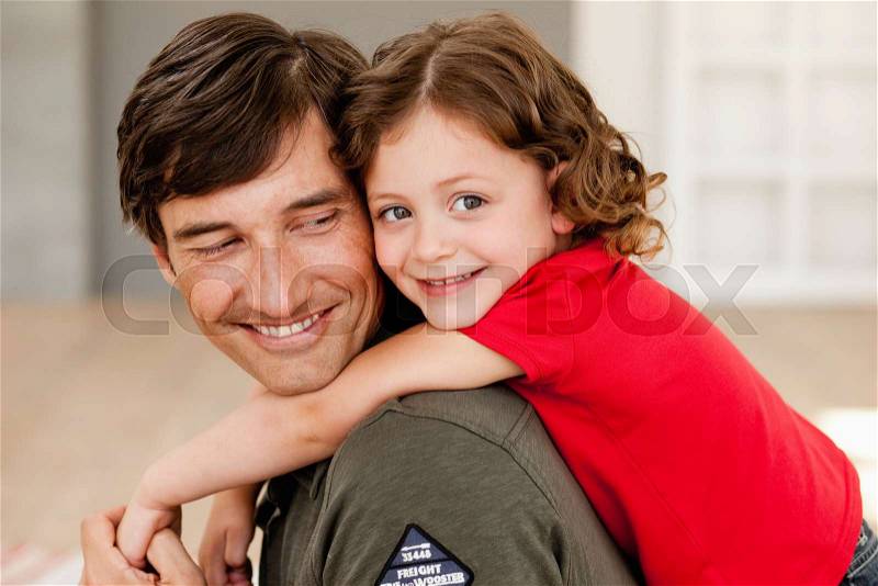 Daughter riding on father's back, stock photo