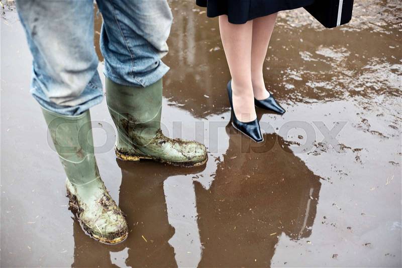 Business woman with farmer in mud, stock photo