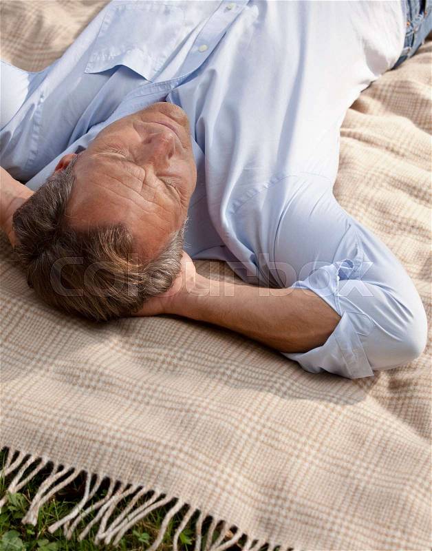 Man lying relaxed on a blanket, stock photo