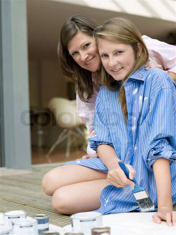 Mother and daughter in painting clothes, stock photo