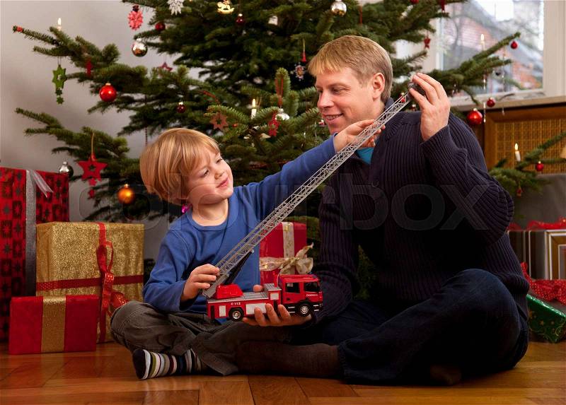 Father, son play with christmas present, stock photo
