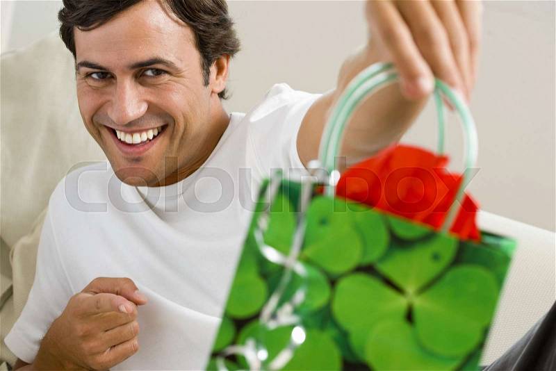 Man holding gift bag, stock photo