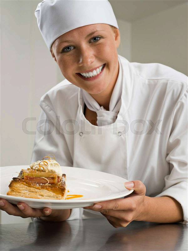 A female chef holding a pastry desert, stock photo
