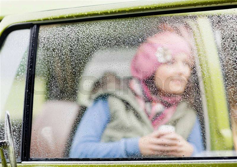 Woman looking out of camper van, stock photo
