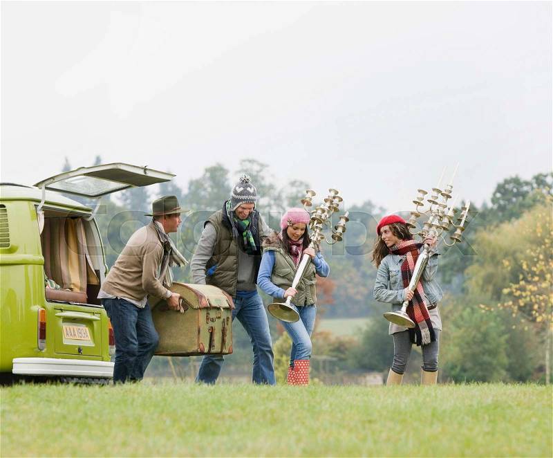People unloading things from camping van, stock photo