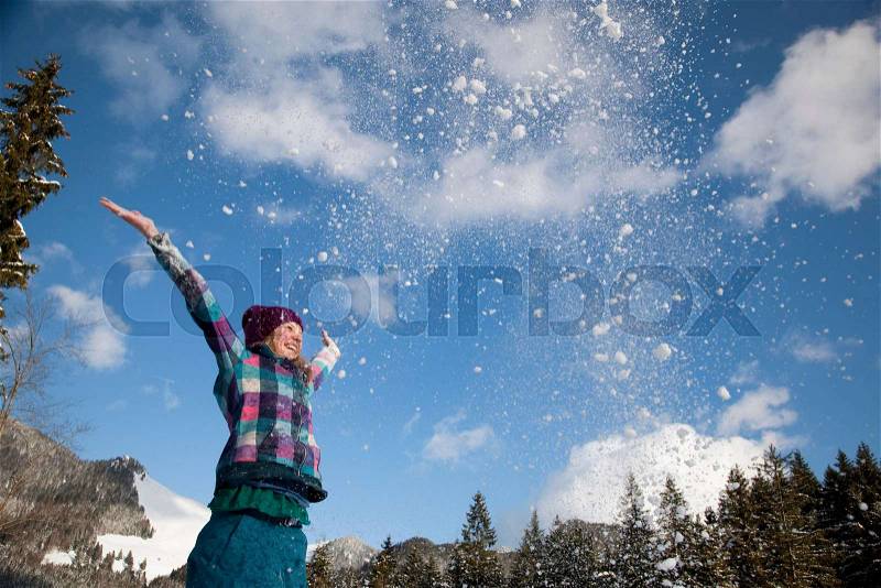 Girl throwing snow into the air, stock photo