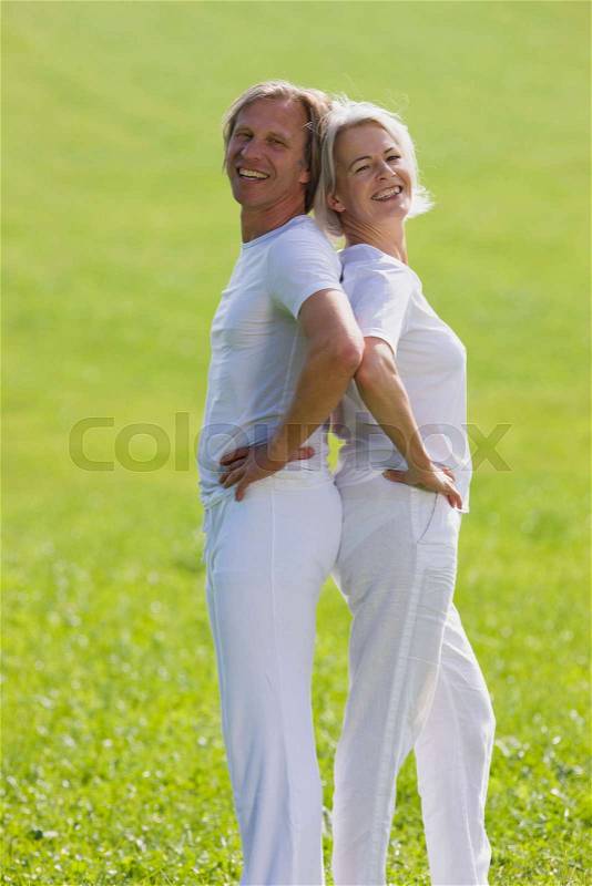 Couple standing back to back, stock photo