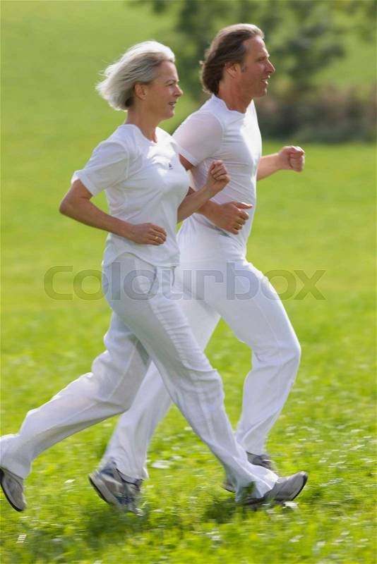 Couple running in field, stock photo