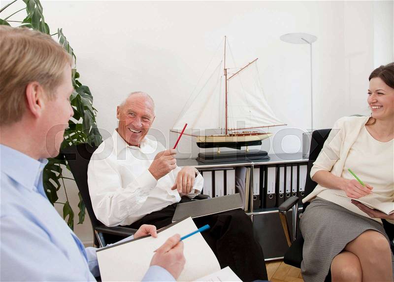Businesspeople discussing papers, stock photo