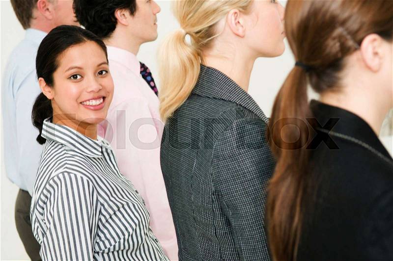 Women in line of people smiles to camera, stock photo