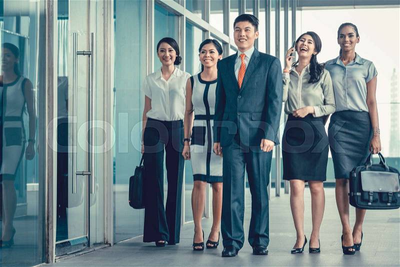 Asian business team of executives walking into office very determined to find some fault in the books they will do revision in , stock photo