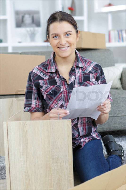 Lady holding instructions for assembling furniture, stock photo