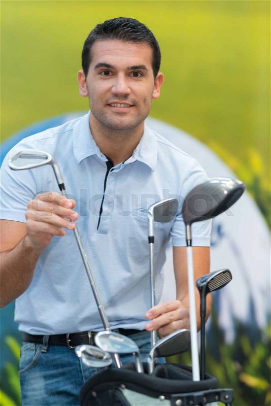 Choosing golf club on retail shop background, stock photo