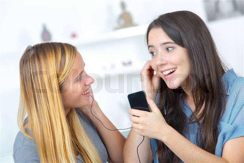 Young women sharing the music, stock photo