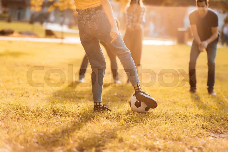 Selective focus of friends playing soccer together in park, stock photo