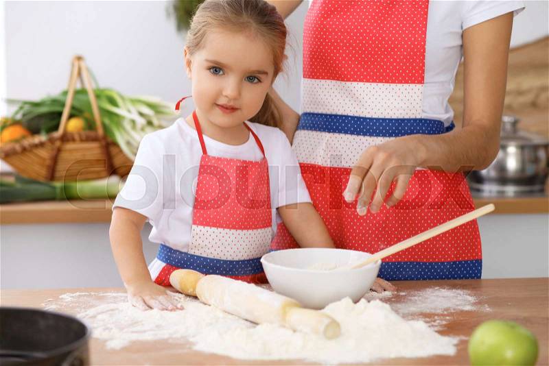 Mother and daughter playing and cooking holiday pie or cookies for Mother\'s day, casual lifestyle photo series in real life interior. Happy family in the kitchen, stock photo
